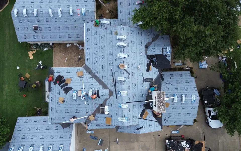 Overhead aerial inspection view of a roof with material staged across the deck